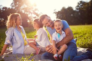 A family sitting on the grass laughing