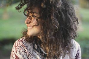 young woman looking on her right side smiling.