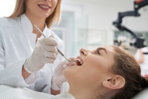 dental hygienist evaluating patient's mouth and teeth